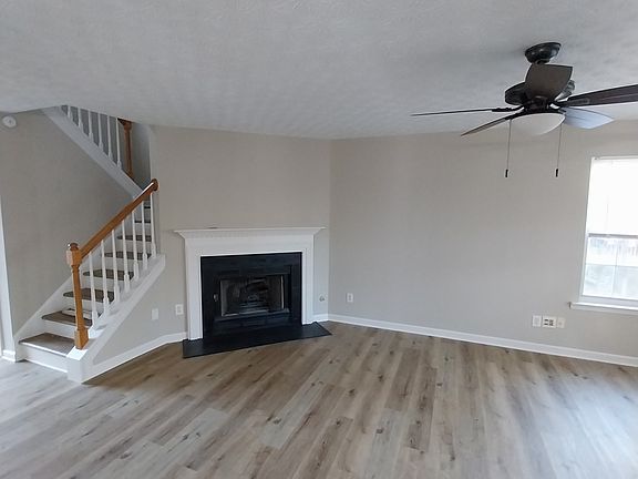 Open floor plan on main level with fireplace and new flooring.