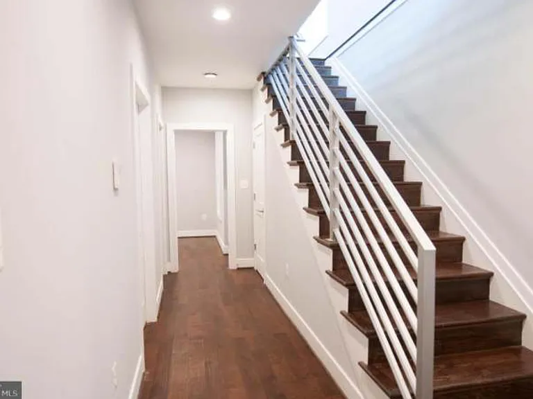 Lower floor view. Storage closet and laundry and dryer in the hallway.