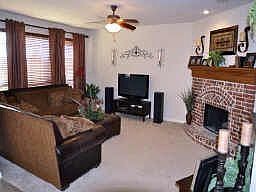 Large,open living room with beautiful corner brick fireplace.