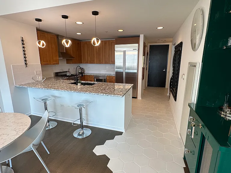 High end stainless steel appliances (stove, microwave, dishwasher, fridge) with plenty of cabinet storage and countertop space