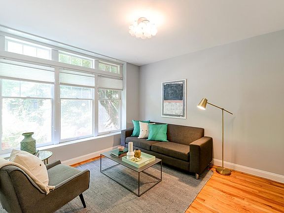 Sunny living room with warm hardwood floors and big windows