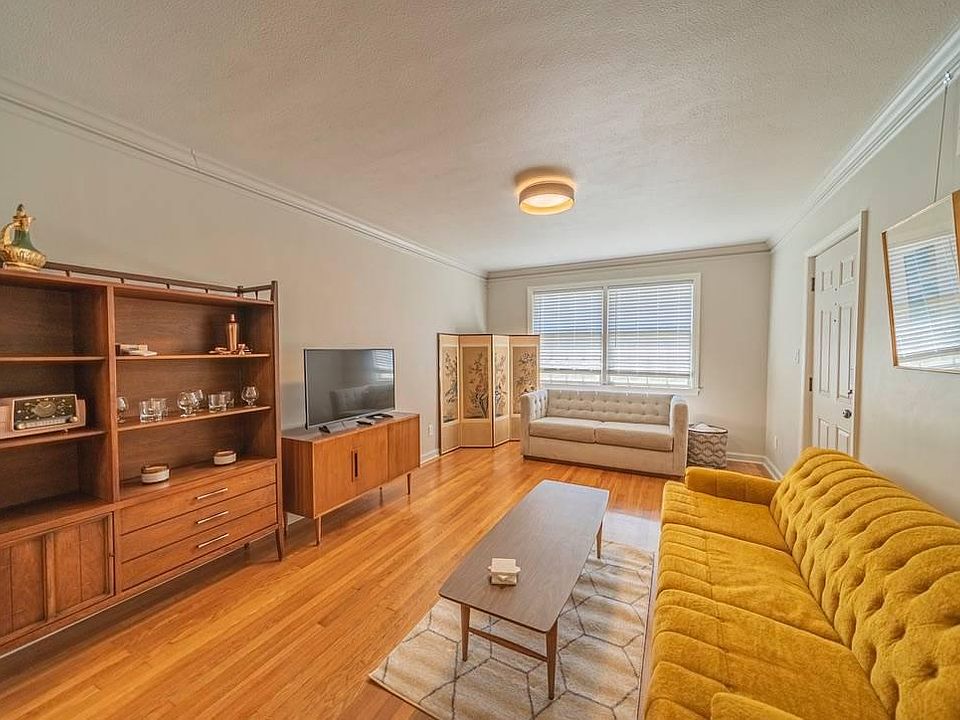 Living room: Midcentury Modern furnishings, smart tv, Amazon Echo, dimmer switch for light fixture, and plenty of natural light with large window and cordless blinds.
