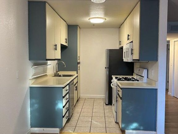 Kitchen with newer dishwasher and newer fridge; repainted cabinets; added new dining area fixture.