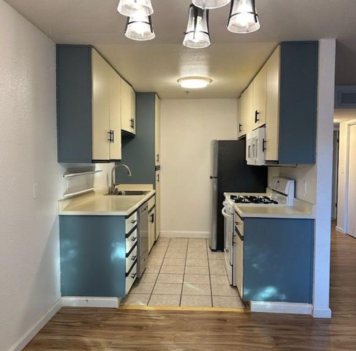 Kitchen with newer dishwasher and newer fridge; repainted cabinets; added new dining area fixture.