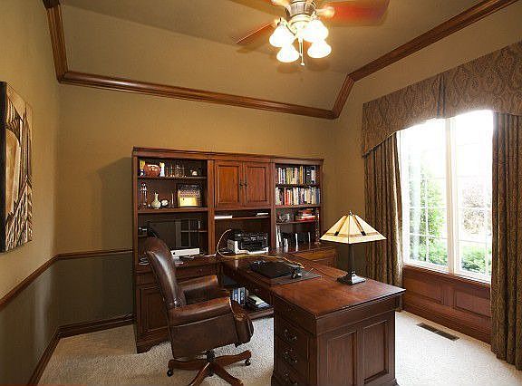 Office withcrown molding, chair rail withlarge window.
