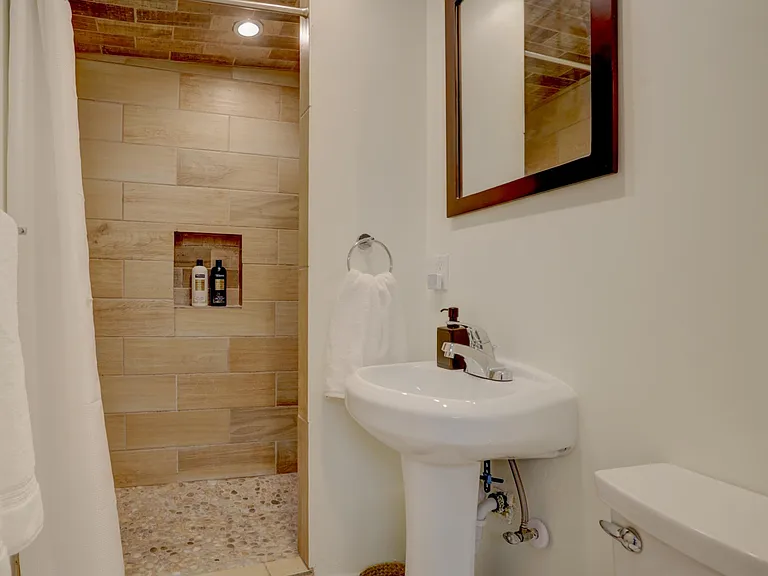 Bathroom with shower and pedistool sink.