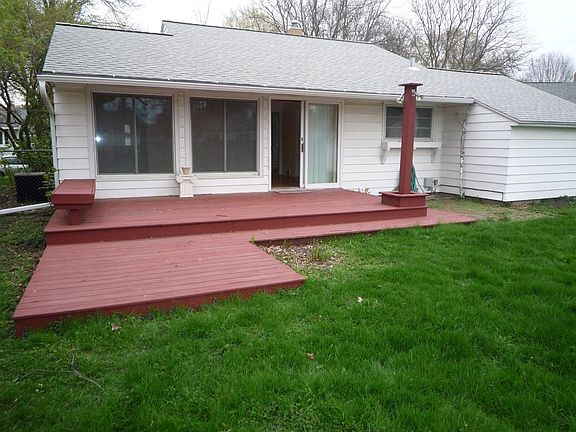 Two level deck in a large fenced-in back yard with access into the living room/dining room area