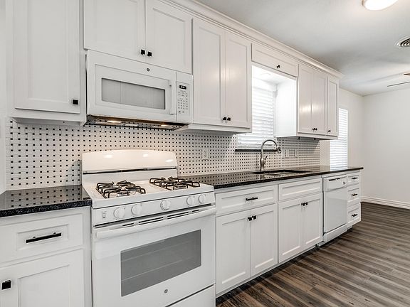 Kitchen Area, granite countertops, new cabinets, double stainless steel sink, faucet/spray house, over range microwave and gas range.