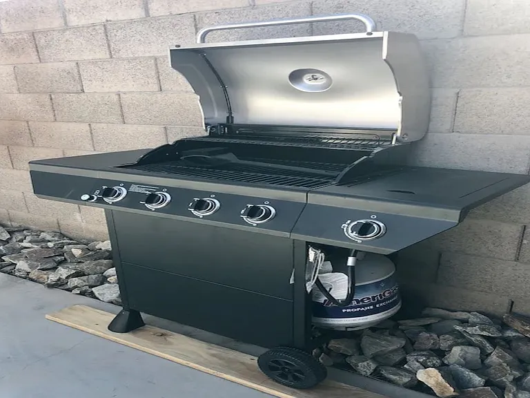 Detached casita BBQ grill at, Tempe rental home. Features a premium multi-burner propane gas grill with an open stainless steel hood, side burner, and dedicated grilling area set against a private block wall. Great outdoor amenity for a Tempe, AZ stay.