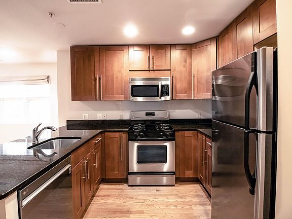 Kitchen with stainless appliances including dishwasher, gas stove, microwave, and refrigerator with ice maker.