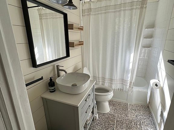 Newly remodeled downstairs bathroom with terrazzo tile, new vanity and toilet.