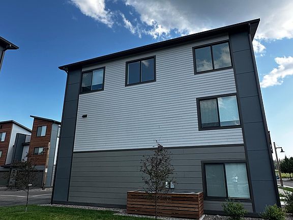 Green space view & side of townhome. Master bedroom window on the bottom. Living room windows on the top with upper left window being the balcony window.