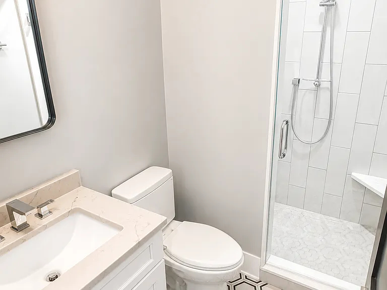 Bathroom with full size shower with tempered glass and built in seating.