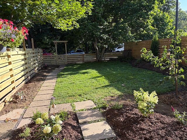 Backyard facing treed backdrop