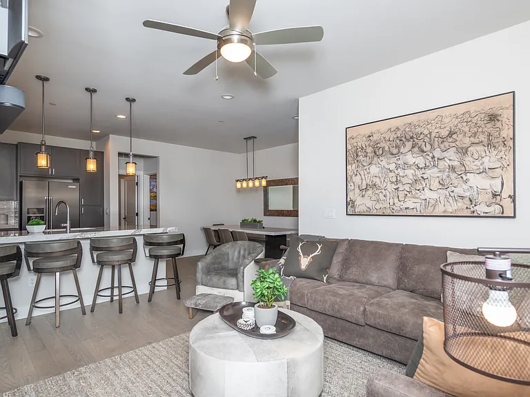 Stylish open kitchen and dining area blending rich cabinetry, quartz countertops, and soft lighting for a warm mountain-modern feel.