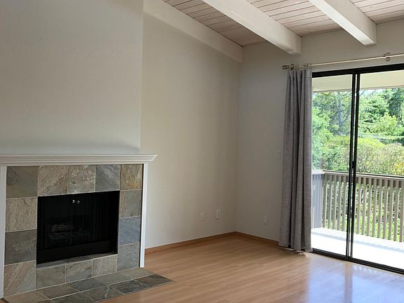 Living room with high ceilings, covered balcony and gas fireplace
