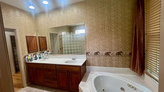 Primary bathroom features pocket doors, private water closet, walk in shower, dual sink vanity with storage, and a jacuzzi jetted tub.