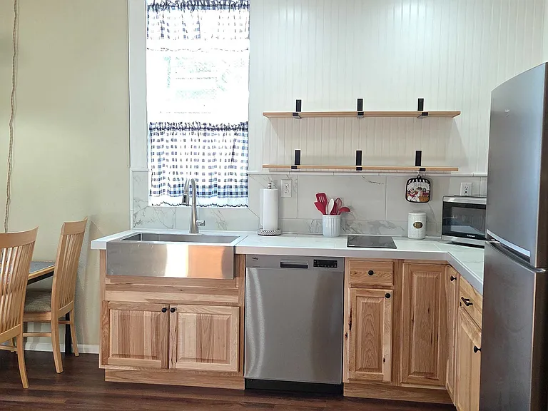 Stainless steel Country sink, new two burner induction cooktop and corner cabinetry with internal rotating lazy susan shelves. Not shown; large 3 in 1 large microwave, connection oven and air fryer.