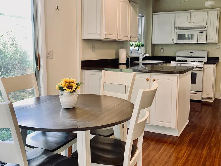 The sizable kitchen eating space receives bright light from the sliding door that provides access to the sitting area on side of the house and backyard.