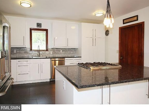 Open kitchen has great flow and lot's of cabinets, a center island, granite counters, high-end stainless steel appliances, and ceramic floors