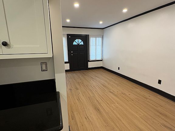 View of main living space from kitchen countertop; brand new flooring throughout, freshly painted