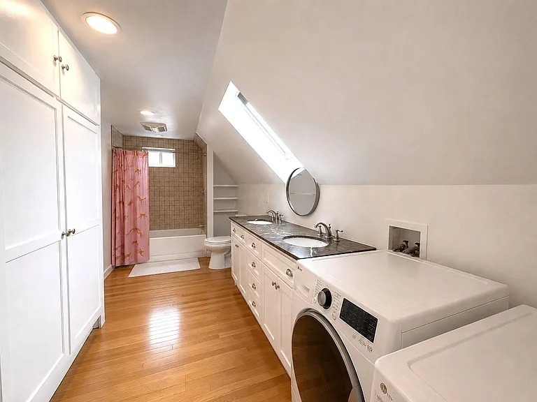 2nd level bathroom with double vanity and washer/dryer