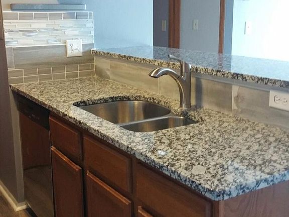 Kitchen w/ granite countertops and stainless steel appliances.