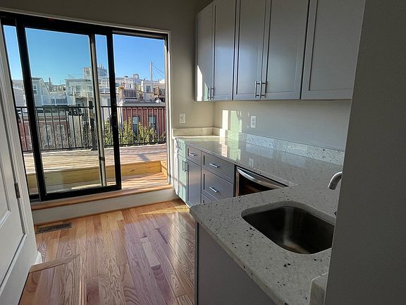 third floor wet bar area with private deck; quartz countertops; sink. wine Fridge; Second fridge and Freezer; stairs to roof top deck