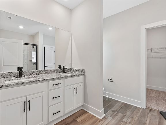 The master bathroom has dual sinks and a glass-enclosed shower