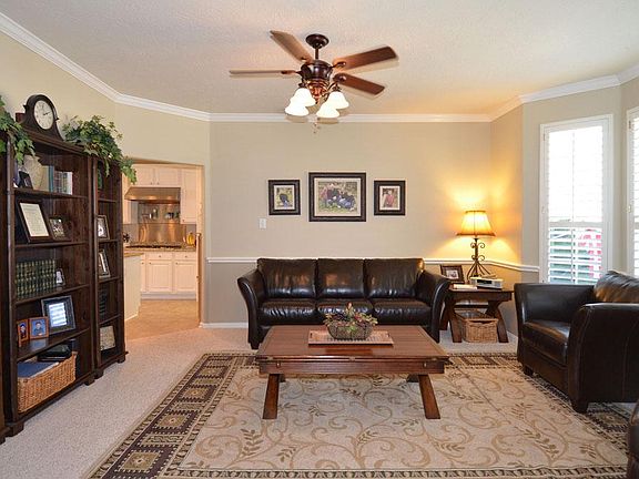 Formal dining room with plantation shutters, currently being used as a sitting area (den).