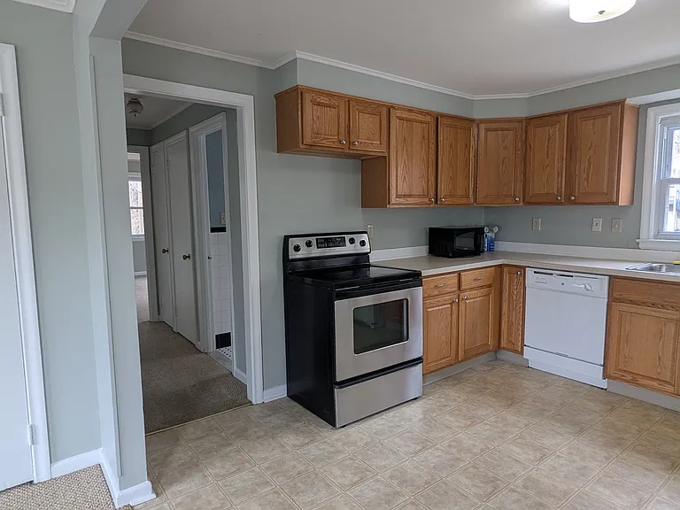 Kitchen. Hallway down to bathroom, bedroom, and door to basment