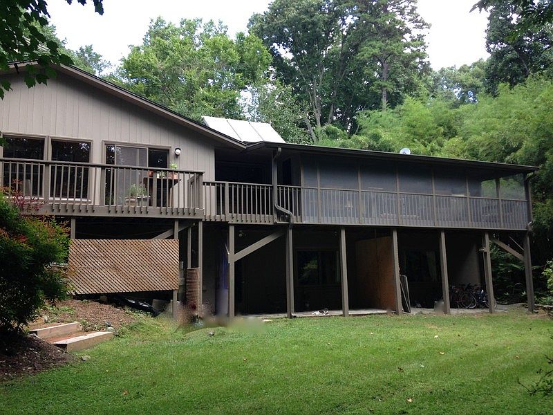 Back View of House : Downstairs deck for apartment. Screened porch above. Very private woods/lawn
