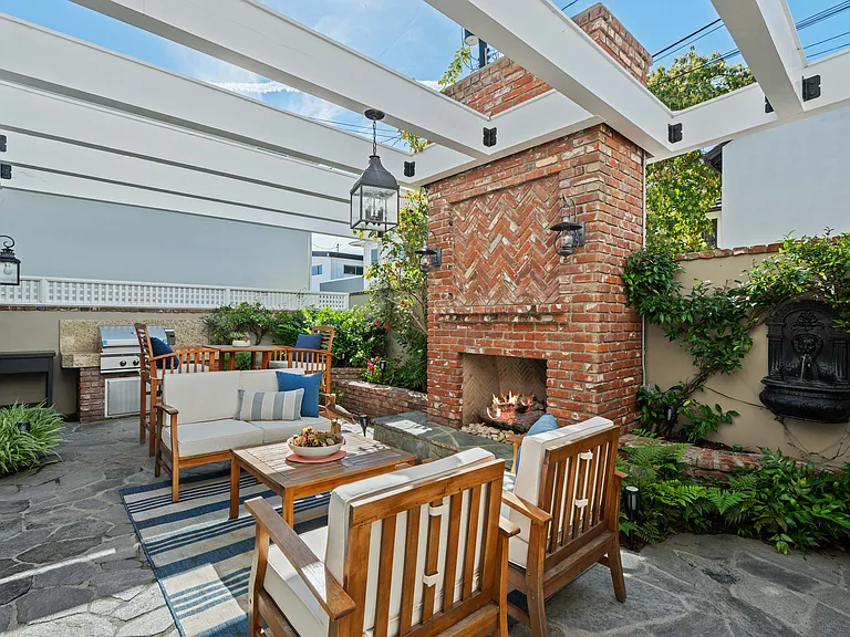Secure and private backyard with greenery, beautiful brick fire place, water feature, professional BBQ and arbor