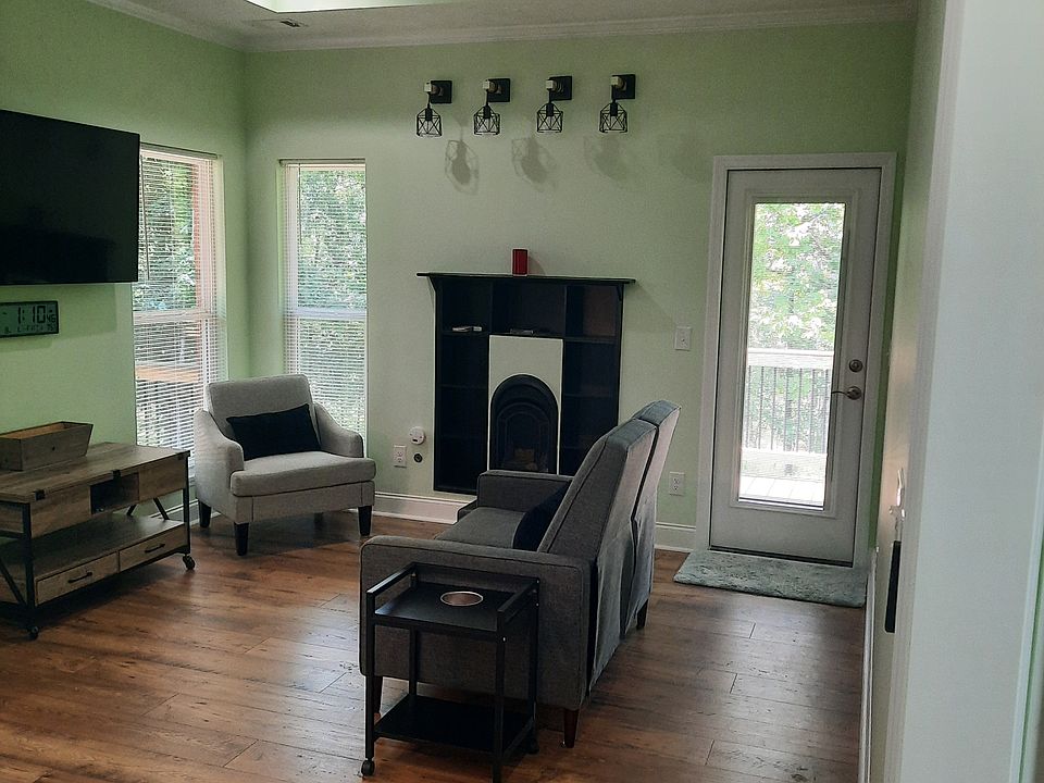 Living room looking out windows and door to raised forest deck.