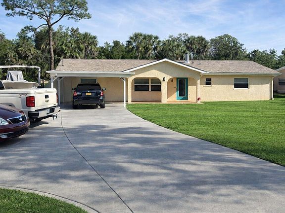 9889 W Halls River Road, House Front, Paved 4 Car Parking, Car Port, Recreational Vehicle Parking Area with 50-amp outlet, water, and sewer connections.