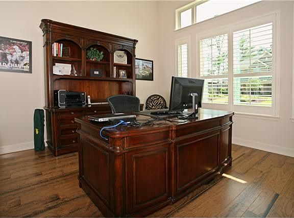 Study has high ceilings, wood floors, and large windows overlooking front grounds for tons of light.