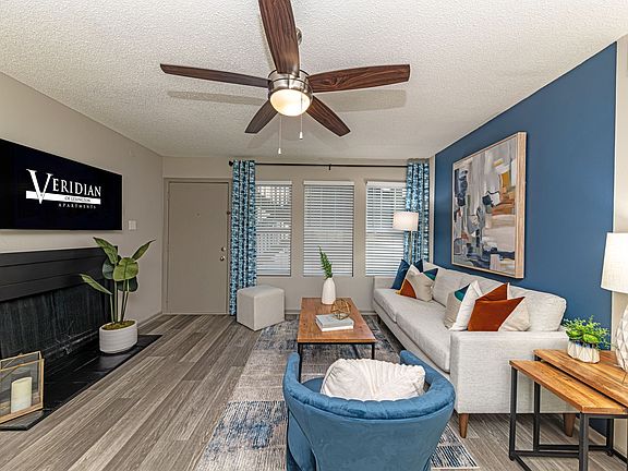 Spacious living room with hardwood-style flooring and overhead lighting