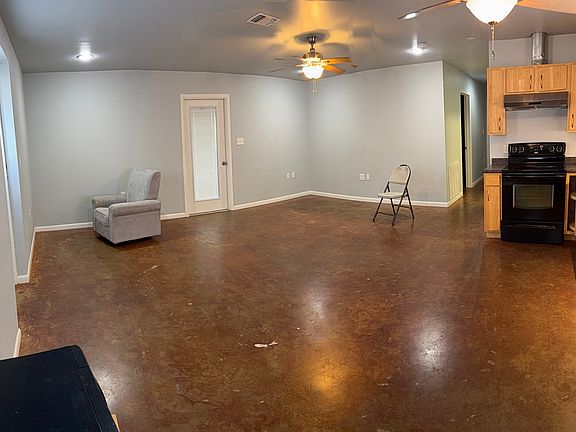 Panoramic view of living area and part of kitchen. Door leads to enclosed parking. Furniture not included.
