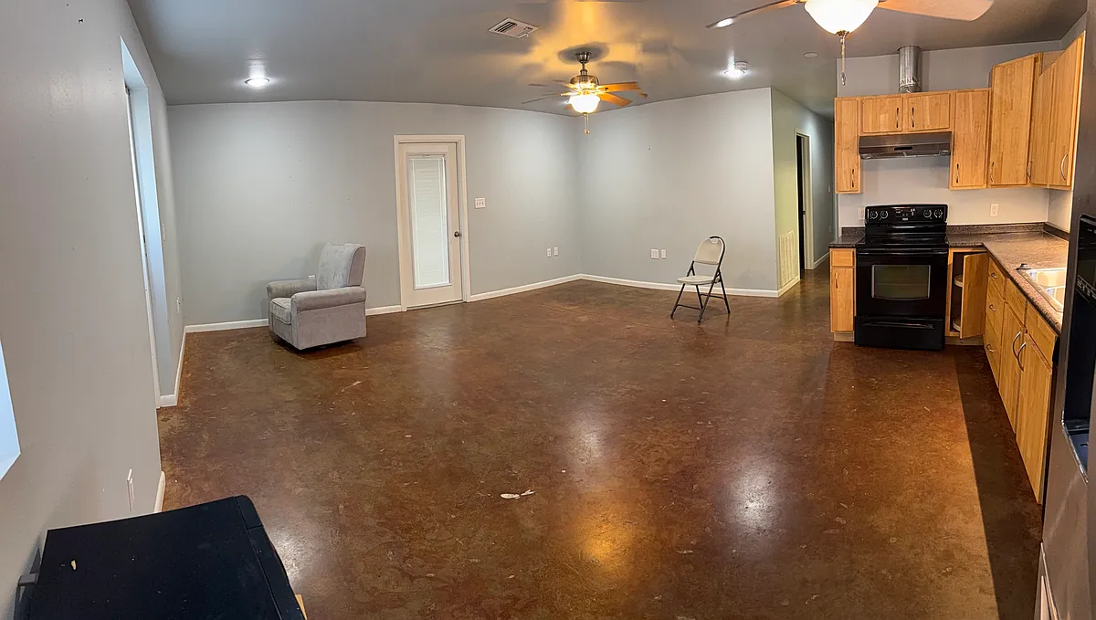 Panoramic view of living area and part of kitchen. Door leads to enclosed parking. Furniture not included. - 11571 Timber Ridge Dr #2