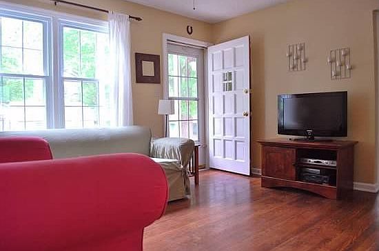 Living room with ceiling fan and wood floors throughout