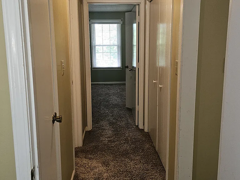 Hallway separating the two bedrooms with oversized laundry closet, linen closet and full bath.