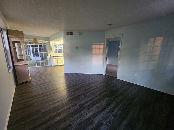 Living Room looking toward dining area and kitchen. Open door leads to large bedroom