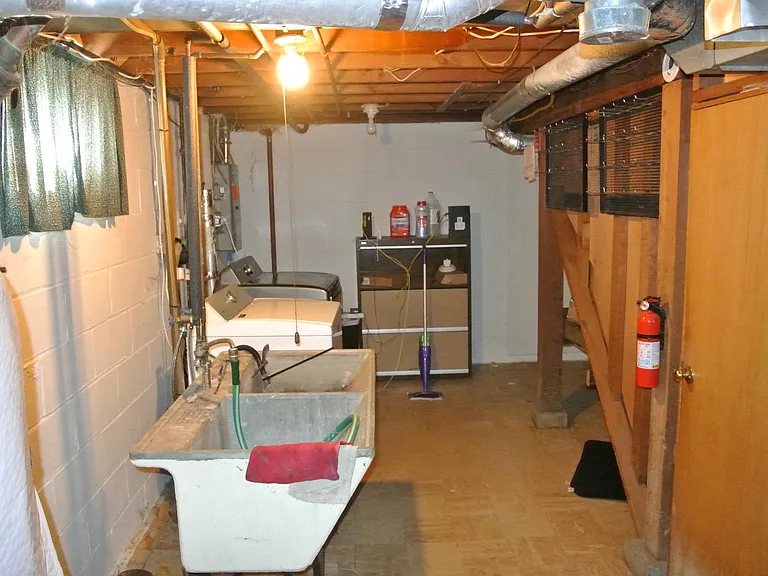 Utility room facing south. Door on right has stairs and going into other side of basement.