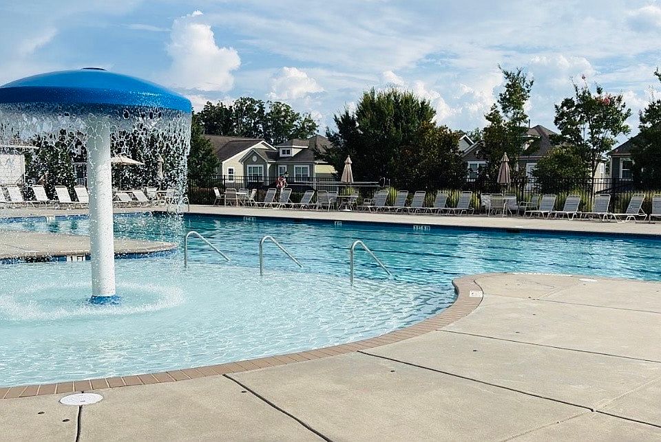 The community offers a pool with two large restrooms (men's and women's, each with 3 toilets), a covered area, umbrellas, lounge chairs, a shower, a kids' playground, and a cozy fireplace.