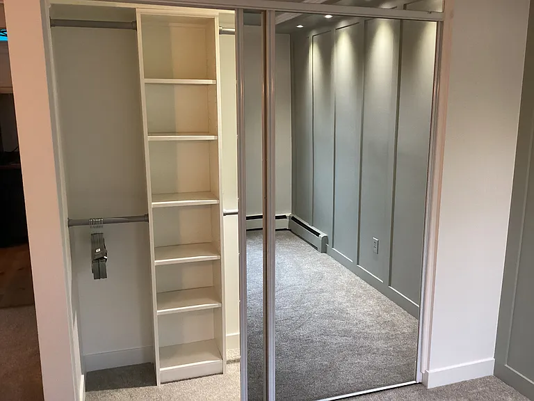 Full bedroom closet with lighting and deluxe storage