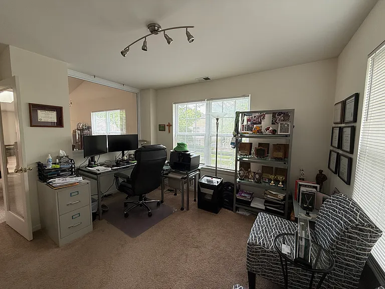 The perfect, quiet work-from-home setup. This spacious room offers plenty of natural light and privacy, easily accommodating a full executive desk, multi-monitor setup, and additional seating - a must-have feature for today's professional lifestyle.