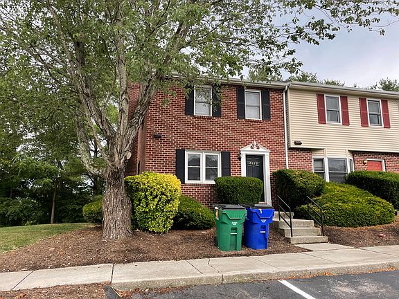 Front of structure, with 2 assigned parking spaces with plenty of additional parking just to the left of the entrance.