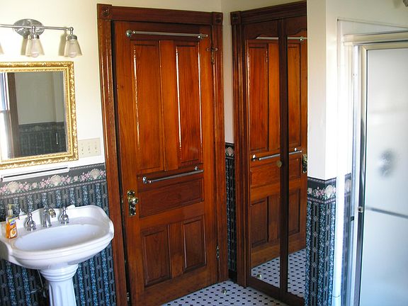 The shower is to the left. The mirrored doors access a linen closet. Notice the classic mosaic tiles? This bathroom is large enough to dance in.