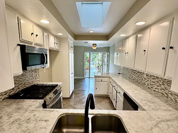 Kitchen- gas range and stainless steel. Note the skylight and the bright light from the dining room door.