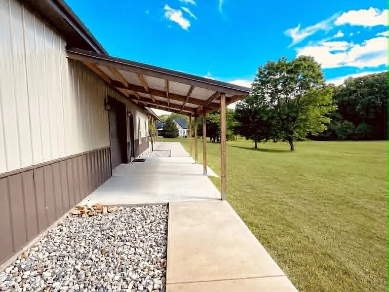 Side covered porch with small garage door. Perfect size for golf-cart, motorcycle, lawn mowever, etc.